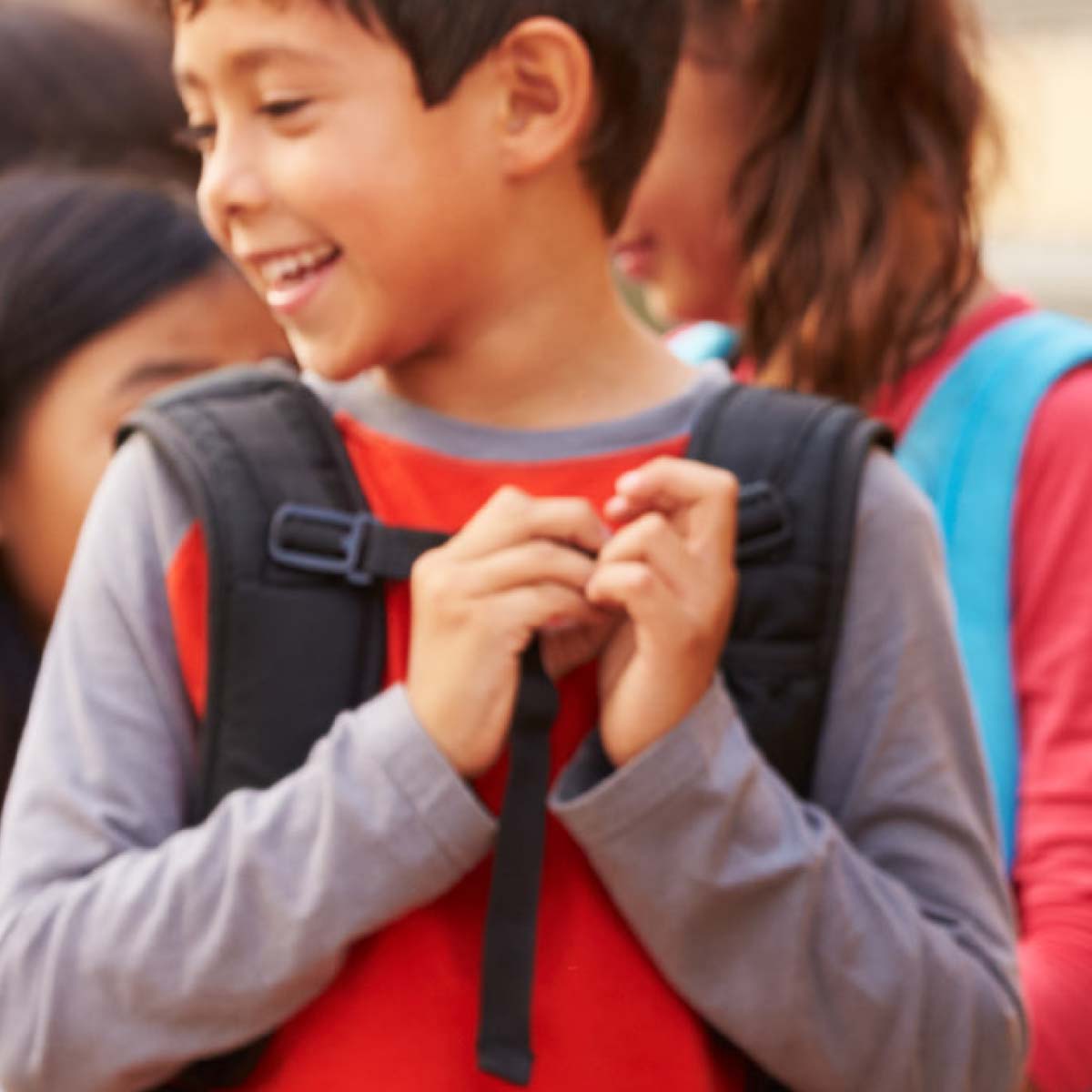 Children with backpacks entering school