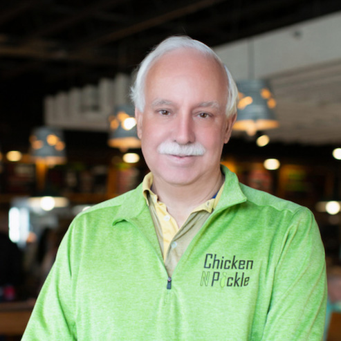 Photo of Dave Johnson wearing green Chicken N Pickle shirt