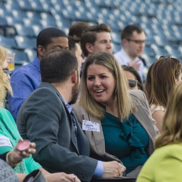 Professionals networking at sporting event.