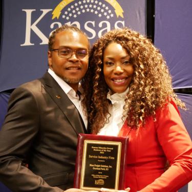 Photo of Gerald and Jy Maze, holding 2021 Kansas Minority-Owned Service Industry Firm of the Year Award
