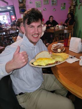 A customer gives a thumbs up enjoying an omelet at The Mixing Bowl